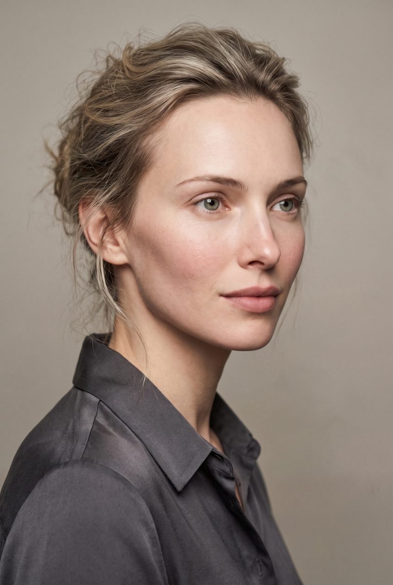 Edith, candidata del cast: ritratto di tre quarti, capelli biondi raccolti, camicia di raso grigio antracite, fondo grigio
